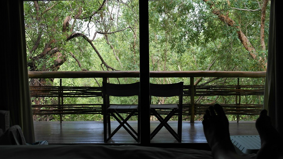 Blick vom Bett hinaus auf die Terrasse im Thakadu River Camp