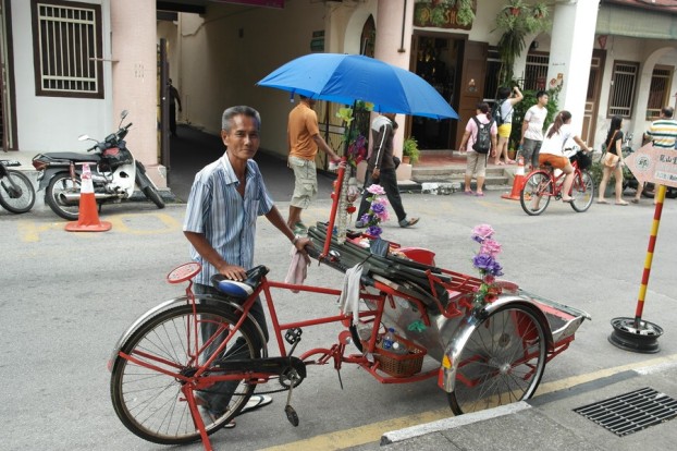 Trishaw Fahrer in den Straßen von Georgetown Penang